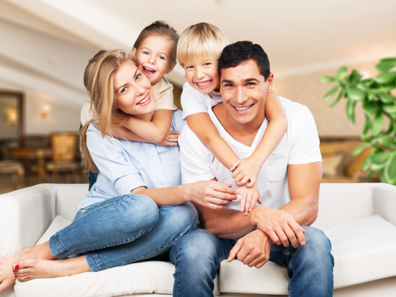 Young family at home smiling at camera
