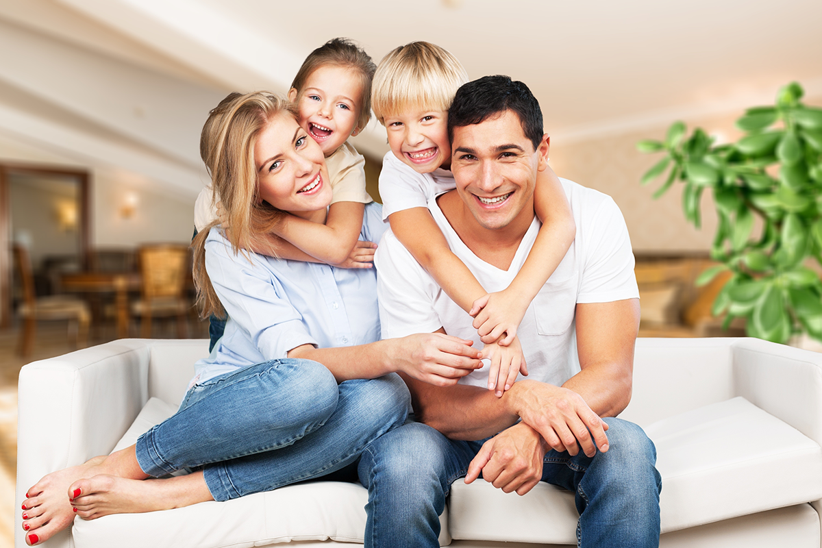 Young family at home smiling at camera